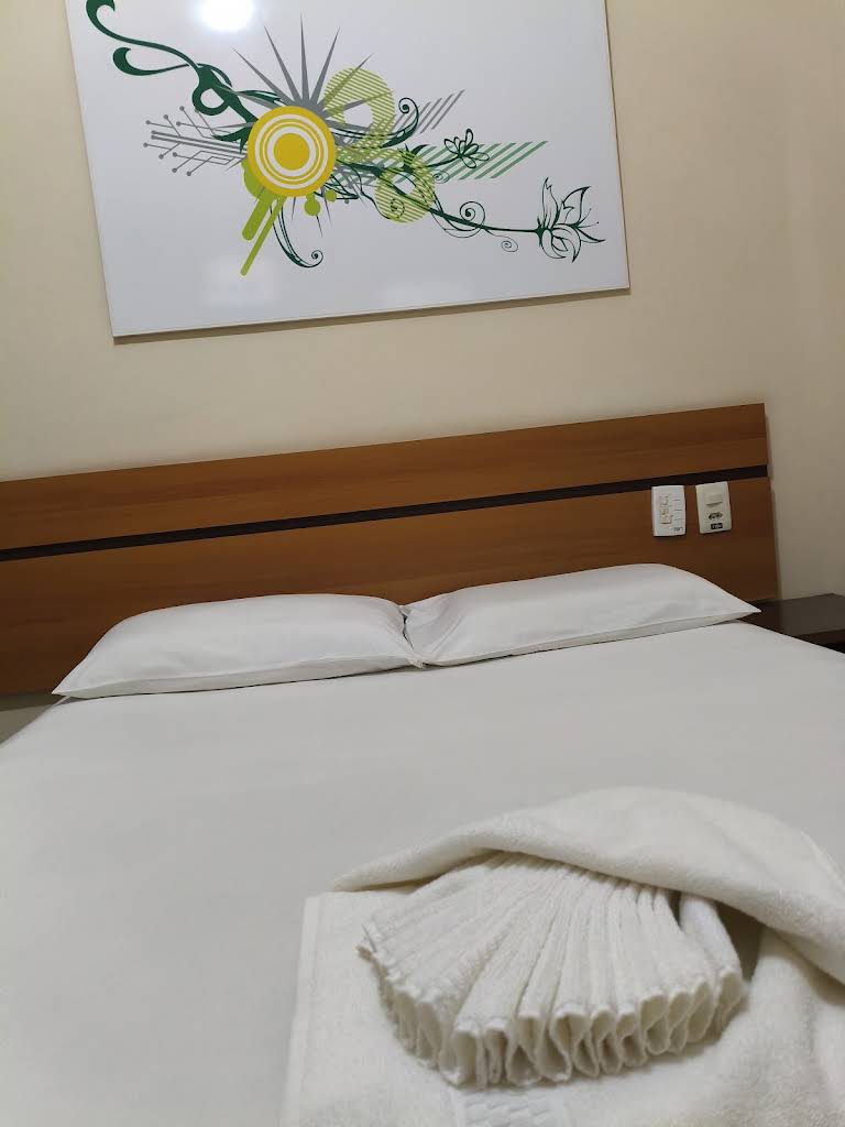 Quarto do Hotel Santo Antônio com camas e janela